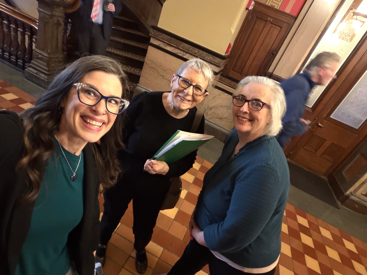 Shawna Anderson smiling with fellow advocates inside the Iowa State Capitol